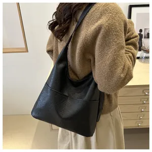 Détail du grand sac hobo noir avec coutures contrastées et texture plissée élégante