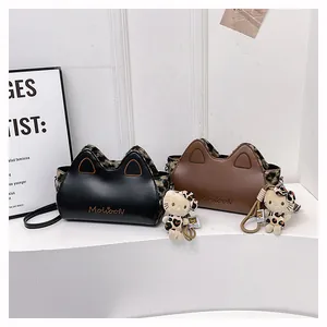 Détail de sacs oreilles de chat noir et marron avec imprimé léopard et pendentifs