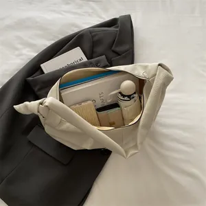 Minimalist beige leather dumpling bag with items showing large storage capacity
