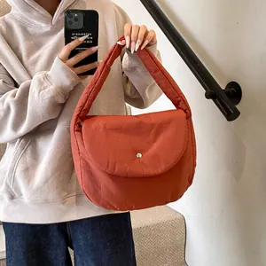 Quilted cotton-padded shoulder bag in brick red with large flap and silver metal buckle
