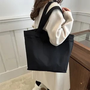Large capacity black canvas tote bag with side pockets for casual minimalist style
