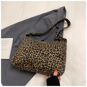 Detail of leopard print canvas tote bag featuring adjustable strap and zipper closure