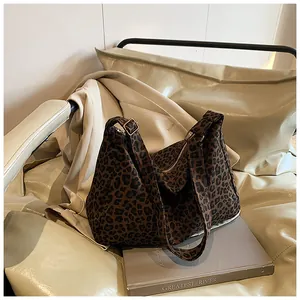 Detailed close-up of leopard print tote bag with adjustable shoulder strap and gold buckle