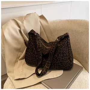 Detailed view of leopard print tote bag featuring metallic zipper and wide shoulder strap
