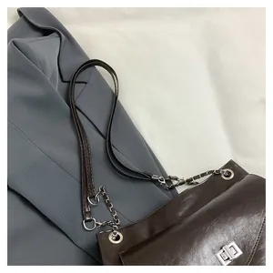 Close-up of the silver twist lock and glossy faux leather texture on this chocolate tote bag