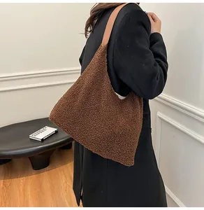 Dettaglio della borsa tote grande in peluche marrone con tracolla in pelle a spalla
