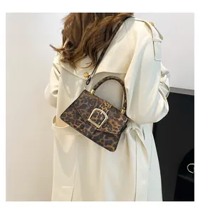 Detail of leopard print shoulder bag with gold metal buckle and adjustable strap