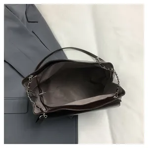Interior view of brown tote bag with zipper pocket and metal chain leather strap