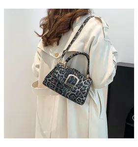 Detail of leopard print handbag with gold U-shaped buckle and adjustable shoulder strap