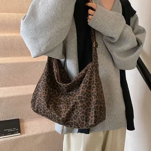 Large leopard print tote bag with adjustable strap shown in a stylish lifestyle setting