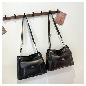 Detail view of retro leather tote bags in black and brown with silver metal turn-locks