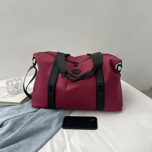 Large burgundy travel duffle bag made of waterproof nylon with adjustable shoulder strap