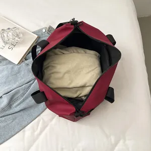 Large burgundy sports travel bag with black handles and spacious interior for gym essentials