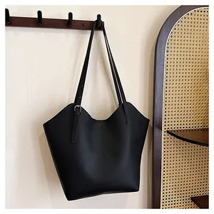 Dettaglio borsa tote in pelle martellata nera con fibbia argentata su gancio a muro