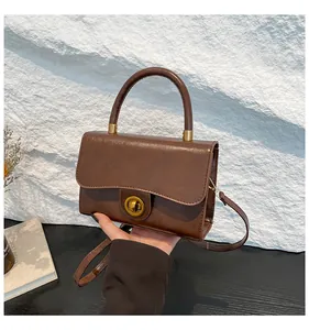 Détail du sac en cuir marron vintage avec un fermoir rotatif en métal doré élégant
