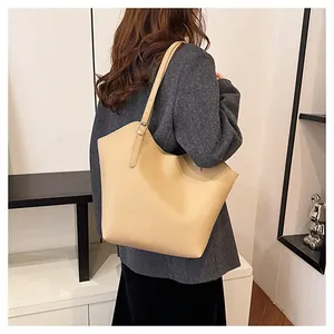 Dettaglio della tracolla regolabile e della grana della pelle sulla borsa tote beige