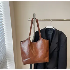 Detail view of vintage dark brown tote bag with glossy texture and silver buckle