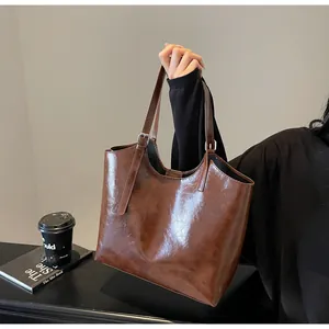 Close-up of vintage brown oil wax leather tote bag with silver metal buckles and straps