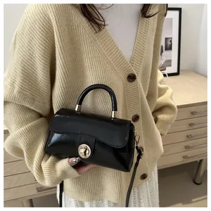 Dettaglio della borsa nera lucida con elegante chiusura a girello in metallo dorato