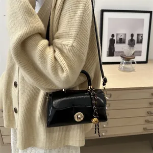 Borsa a mano quadrata in pelle nera lucida con chiusura dorata e ciondolo intrecciato