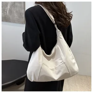 Close-up of off-white large canvas tote bag showing wide strap and metallic zipper detail