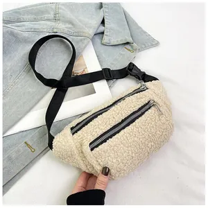 Detail of off-white sherpa waist bag with black zippers and adjustable nylon strap