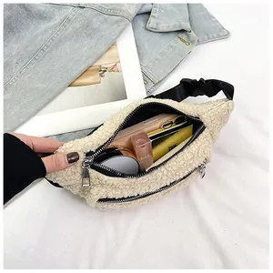 Fleece waist bag showing spacious interior with phone and cosmetics on denim jacket