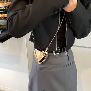 Golden heart-shaped geometric clutch bag with metallic mirror finish and chain strap