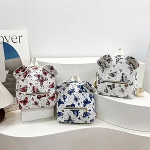 Mini backpack with bow patterns and bear ear design on a clean white display stand