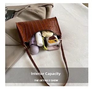 Vue intérieure du sac marron à motif crocodile avec parapluie et cosmétiques