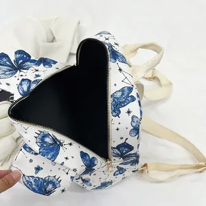 Top view of a white bow commute backpack featuring blue butterfly and star patterns