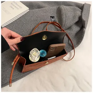 Brown embossed faux leather crossbody bag showing internal storage for phone and makeup