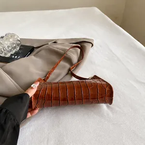 Détail montrant la structure inférieure résistante à l'usure du sac à main marron croco