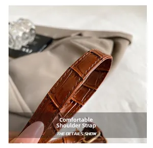 Détail macro de la bandoulière en cuir motif crocodile avec surpiqûres de qualité sac