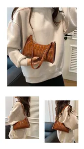 Détails du sac baguette vintage en cuir marron à motif crocodile et sa texture brillante