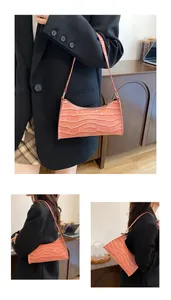 Gros plan détaillé sur la texture crocodile rose et la fermeture éclair du sac baguette