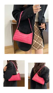 Gros plan détaillé du cuir PU à motif crocodile rose vif sur un sac baguette en croissant