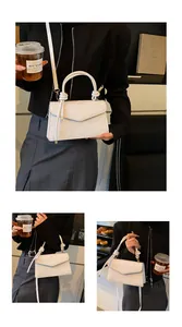 Detail of white crossbody bag with embossed floral texture and knotted handle strap