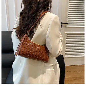 Détail du sac porté épaule marron à motif crocodile avec texture en cuir poli et fermeture