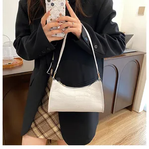 Gros plan sur le sac baguette blanc avec motif crocodile et design épuré moderne
