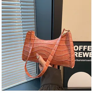 Détail du sac à bandoulière rose à motif crocodile en cuir synthétique brillant