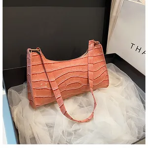 Détail de la texture crocodile rose corail et de la fermeture éclair du sac baguette chic