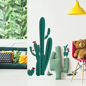 Detail of green cactus wall decals arranged on a white wall in a cozy living room setup