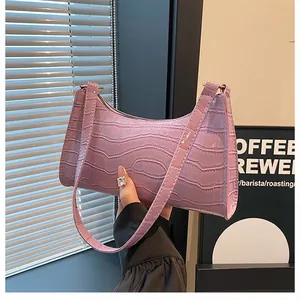 Détail du sac baguette violet clair avec texture crocodile brillante et couture fine