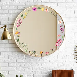 Détail d'un miroir mural rond avec des autocollants floraux colorés sur un mur de briques