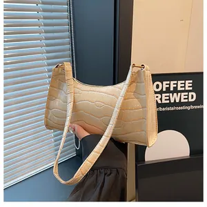 Détail de la texture crocodile crème et de la poignée du sac baguette au style minimaliste