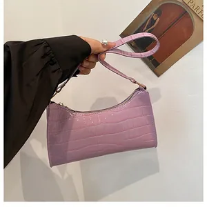 Détail du sac baguette lilas à motif crocodile avec fermeture éclair en métal et bandoulière