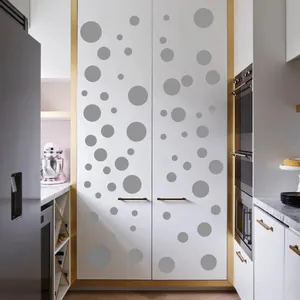 Modern gray polka dot wall stickers in various sizes on a minimalist kitchen cabinet