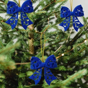 Three navy blue felt bow Christmas tree ornaments with gold strings and cutout design