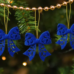 Detail of laser-cut blue felt bow ornaments with gold strings for Christmas tree decor